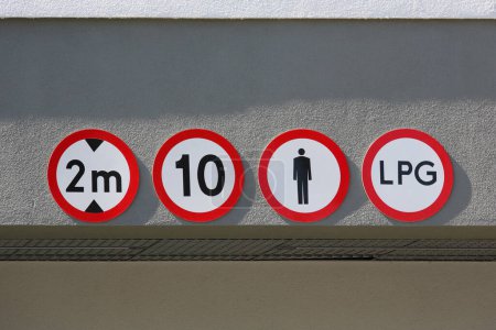 Road signs placed above the entrance to the underground car park, intended for a large number of cars, inform about the rules of access and the conditions of use of this car park.