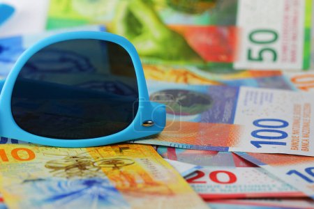 Photo for Sunglasses on several Swiss franc banknotes. This theme can be used to illustrate a wide range of financial topics. - Royalty Free Image