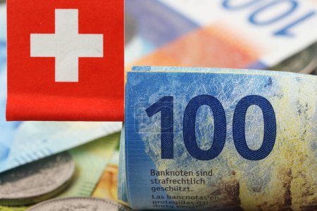 Photo for Swiss franc banknotes in denominations of one hundred francs. A small Swiss flag is affixed. CHF paper money, the introduction of these banknotes was happened from April 2016 to 2019 - Royalty Free Image