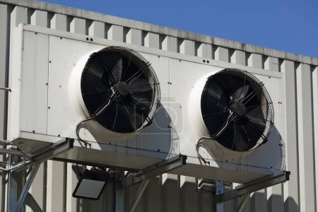 Téléchargez les photos : Deux ventilateurs dans un boîtier, une partie extérieure du système de climatisation et de ventilation monté sur le mur extérieur du bâtiment du centre commercial. - en image libre de droit