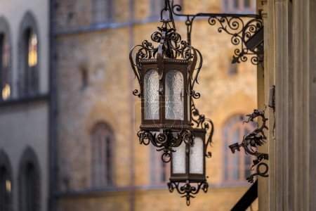 Téléchargez les photos : Lampadaires extérieurs gothiques décorés avec façades floues sur la Via de Tornabuoni, rue commerçante haut de gamme majeure, Centro Storico, Florence Italie - en image libre de droit