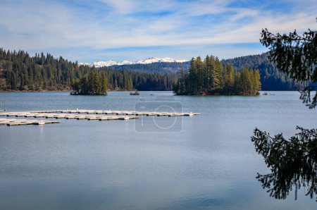 Le lac Jenkinson à Sly Park et la neige recouvraient les montagnes de la Sierra Nevada en arrière-plan dans le nord de la Californie en hiver