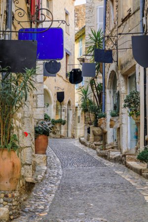 Photo for Traditional old stone houses with gift shops on a street in the medieval town of Saint Paul de Vence, French Riviera, South of France - Royalty Free Image