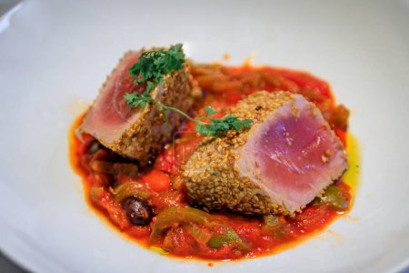 Photo for Sesame crusted rare seared tuna over piperade pepper sauce at a restaurant in Saint Paul de Vence, medieval town in French Riviera, South of France - Royalty Free Image