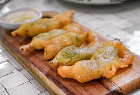 Photo for Traditional delicacy from South of France, fried courgette or zucchini flowers at a restaurant, Saint Paul de Vence, French Riviera, South of France - Royalty Free Image