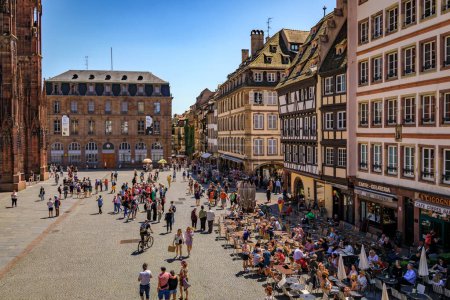 Foto de Estrasburgo, Francia - 31 de mayo de 2023: Vista aérea de la fachada de la Catedral de Notre Dame, tiendas y restaurantes en casas de entramado de madera, y el Palacio Palais Rohan - Imagen libre de derechos