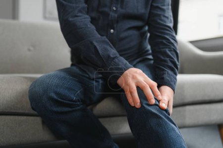Photo for Senior man suffering from pain in knee at home. - Royalty Free Image
