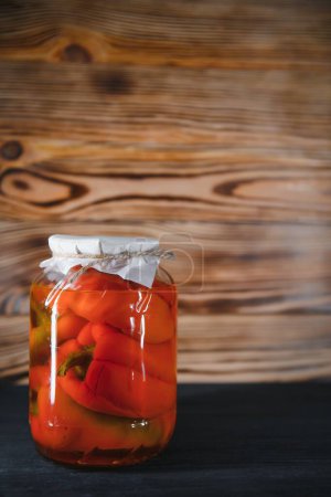 Foto de Red peppers pickled in glass jars. - Imagen libre de derechos
