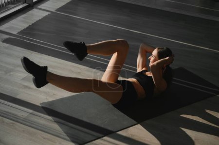 Photo for Beautiful athletic woman working ab intervals in fitness. - Royalty Free Image