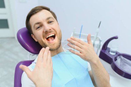 Dental care concept. Handsome young guy at the dentist's office