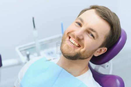 Téléchargez les photos : Concept de soins dentaires. Beau jeune homme au cabinet du dentiste - en image libre de droit