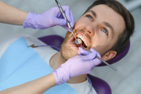Photo for Man having teeth examined at dentists. - Royalty Free Image