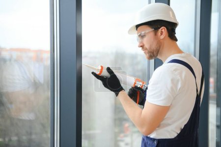 Photo for Worker installing new plastic pvc window. - Royalty Free Image