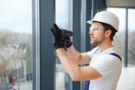 Photo for Service man installing window with screwdriver. - Royalty Free Image