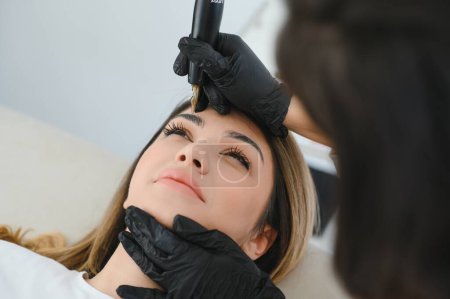 Téléchargez les photos : Maître faisant maquillage permanent des sourcils
. - en image libre de droit
