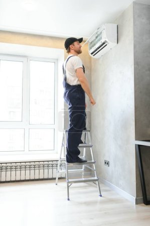 Téléchargez les photos : Spécialiste nettoie et répare le climatiseur mural
. - en image libre de droit