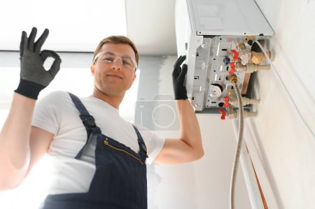 Foto de Professional boiler service: qualified technician checking a natural gas boiler at home. - Imagen libre de derechos