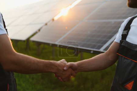 Foto de Workers shaking hands on a background of solar panels on solar power plant - Imagen libre de derechos