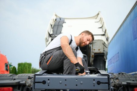 Photo for Semi Truck Under Maintenance. Caucasian Truck Mechanic Working to Fix the Tractor - Royalty Free Image