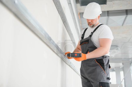 Photo for Worker install a plasterboard wall. - Royalty Free Image