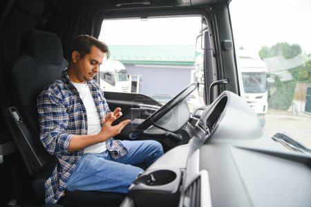 Téléchargez les photos : Un jeune camionneur indien est assis au volant. - en image libre de droit