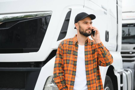 Foto de Hombre camionero hablando por teléfono por su camión blanco. - Imagen libre de derechos