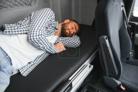 Téléchargez les photos : Chauffeur de camion profitant lit cabine confortable à l'intérieur de son camion. - en image libre de droit