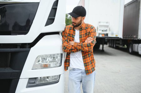 Foto de Retrato del joven camionero barbudo parado junto a su vehículo. Servicio de transporte. Camión conductor trabajo. - Imagen libre de derechos
