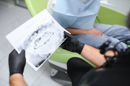 Foto de El dentista muestra una radiografía de mandíbula. Concepto de servicios dentistas. - Imagen libre de derechos