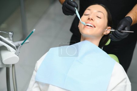 Photo for Dentist examining a patient's teeth in the dentist. - Royalty Free Image
