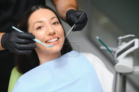 Photo for Dentist examining a patient's teeth in the dentist. - Royalty Free Image