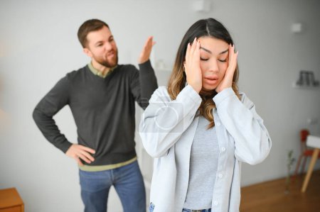 Hombre emocional haciendo gestos y gritando a su esposa, pareja joven teniendo peleas en casa. Concepto de abuso doméstico.