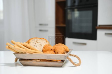 Photo for A kraft box with bread products, donuts, croissants in the kitchen. - Royalty Free Image