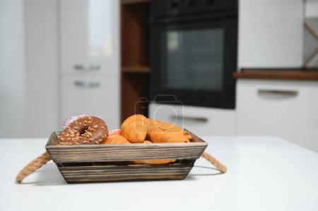 Photo for A kraft box with bread products, donuts, croissants in the kitchen. - Royalty Free Image