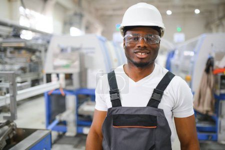 Foto de Un trabajador afroamericano en una fábrica de marcos de ventanas de plástico. - Imagen libre de derechos