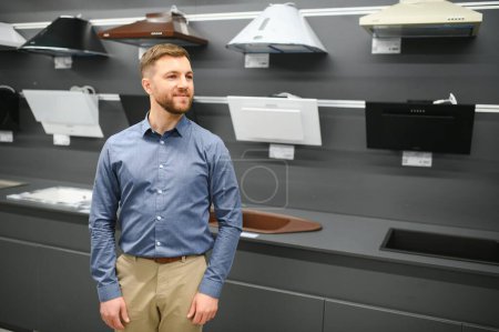 A man chooses a cooker hood in a store.