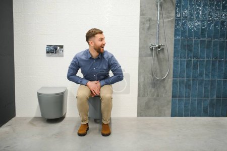 Man sitting on the toilet at the building market.