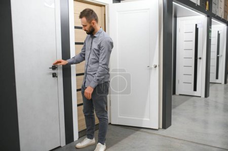 A man chooses doors in a hardware store for his apartment.