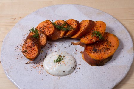 Oven baked sweet potatoes on a plate on vintage wood.