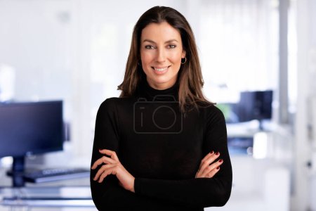 Photo for Portrait of attractive middle aged business woman wearing turtleneck sweater while standing at islated dark background. Copy space. - Royalty Free Image