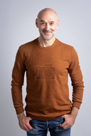 Téléchargez les photos : Portrait d'un homme mature confiant à tête chauve. Homme âgé portant un pull et regardant la caméra sur fond blanc. - en image libre de droit