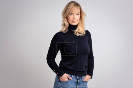 Photo for Portrait of an attractive woman smiling and looking at camera. Blond haired female wearing casual clothes and standing against isolated white background. Copy space. Studio shot. - Royalty Free Image