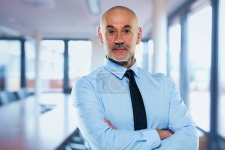 Foto de Retrato de un hombre profesional de mediana edad con camisa y corbata y de pie en la sala de conferencias. - Imagen libre de derechos