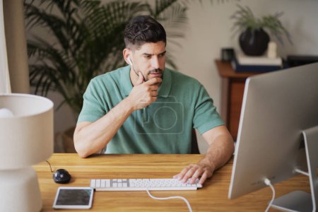 Photo for Mid aged confident businessman sitting at desk and using computer for work. Professional man having web conference at home. Home office. - Royalty Free Image