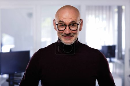 Photo for Handsome casual businessman standing at the office. Bald man wearing turtleneck sweater and glasses. - Royalty Free Image