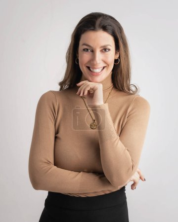 Photo for Close-up of an attractive mid aged woman wearing turtleneck sweater and looking at camera against isolated background. Copy space. - Royalty Free Image
