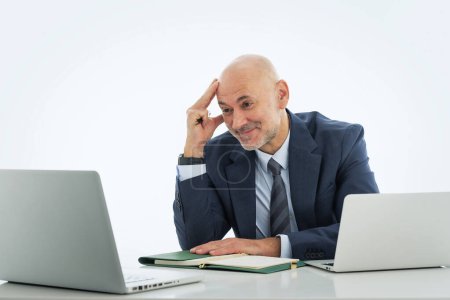 Téléchargez les photos : Homme d'affaires d'âge moyen utilisant un ordinateur portable pour travailler sur fond blanc isolé. Homme professionnel confiant ayant un appel vidéo. - en image libre de droit