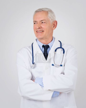 Porträt eines grauhaarigen Arztes vor isoliertem Hintergrund. Professioneller Mann mit Laborkittel und Stethoskop um den Hals. Kopierraum.