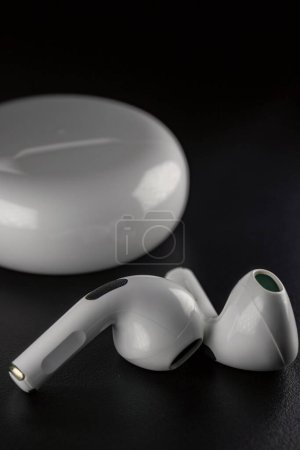 Photo for Small white headphones on a black background - Royalty Free Image