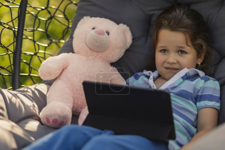 Photo for Girl holding a tablet while relaxing in nature - Royalty Free Image